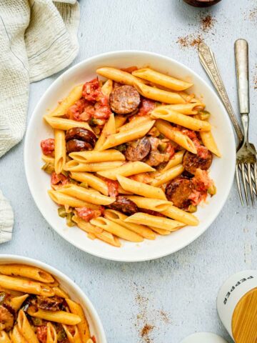 a bowl of creamy cajun pasta and tomatoes.