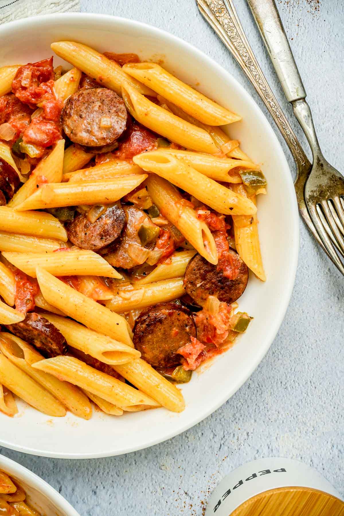 a bowl of pasta and sausage in a cream sauce.