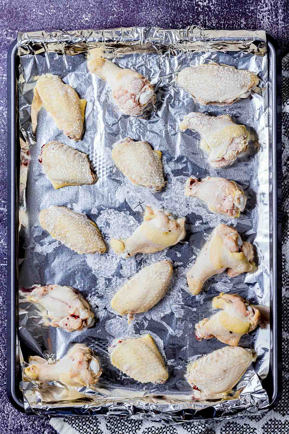 wings coated with flour on a baking sheet.