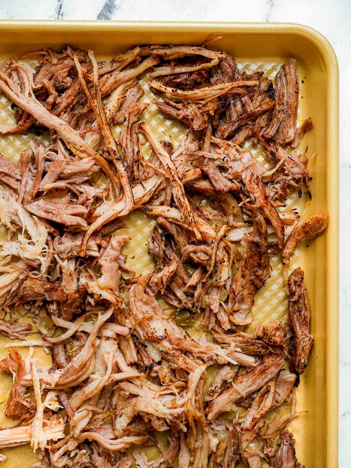 browned crispy shredded pork on a baking sheet.