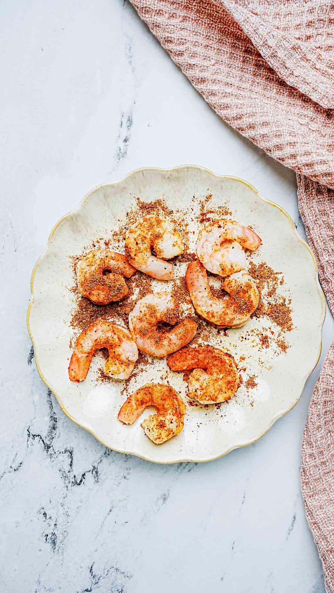 raw, seasoned shrimp on a plate.