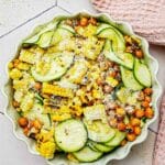 zucchini, corn and chickpea salad with cheese grated on top.