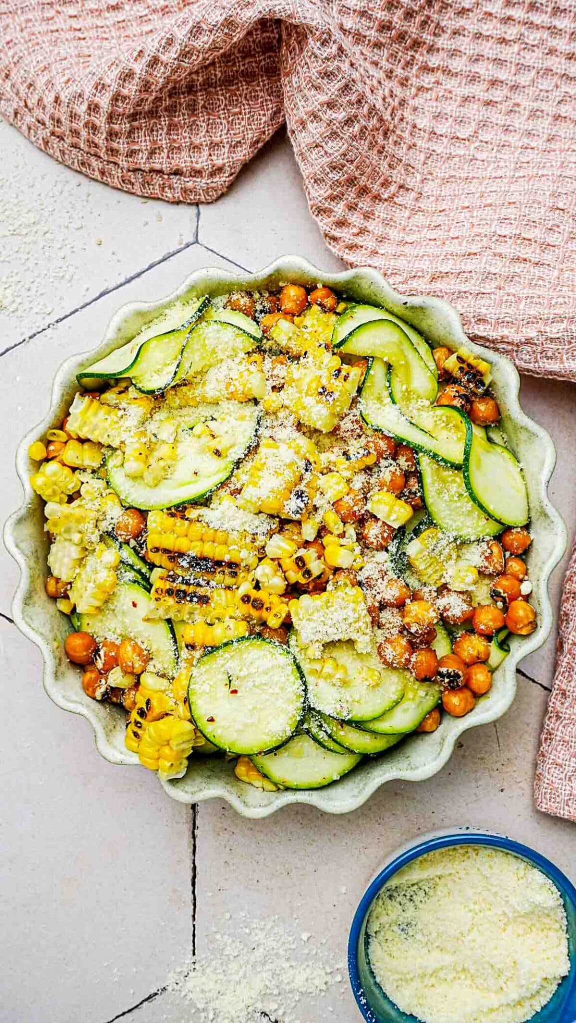 zucchini, corn and chickpea salad with cheese grated on top.