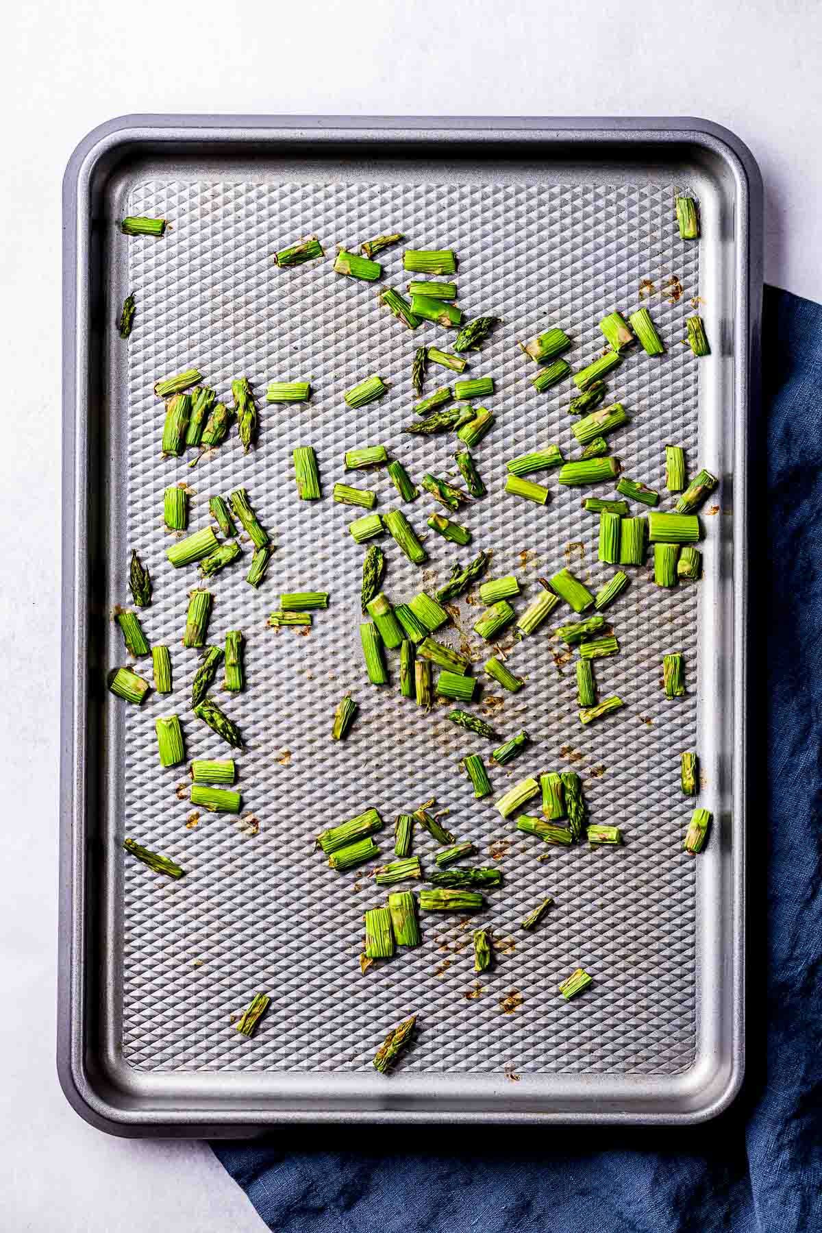 asparagus pieces on a baking sheet.