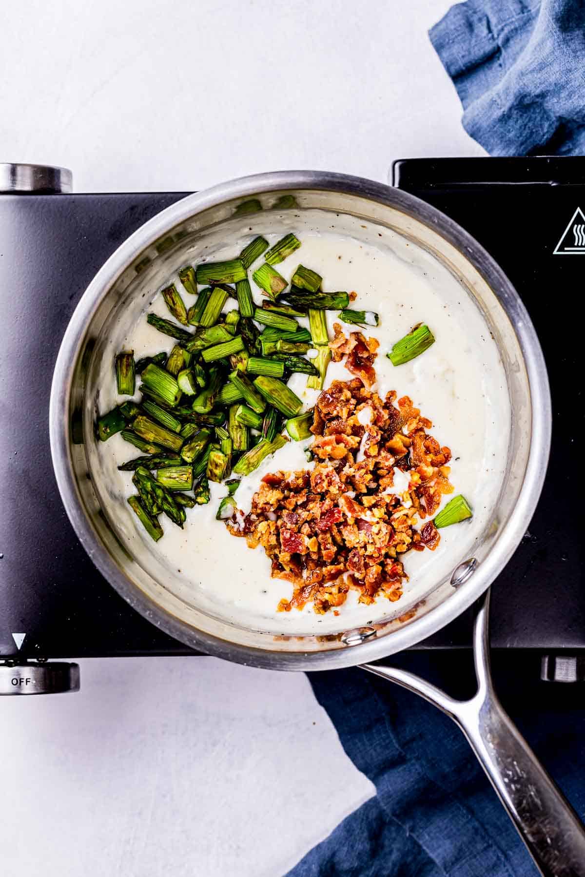 asparagus and bacon in a white sauce.