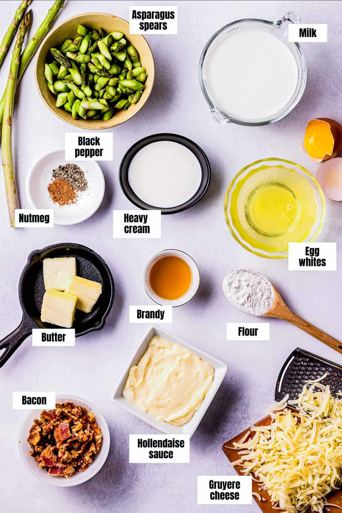 ingredients for asparagus souffle on a white board.